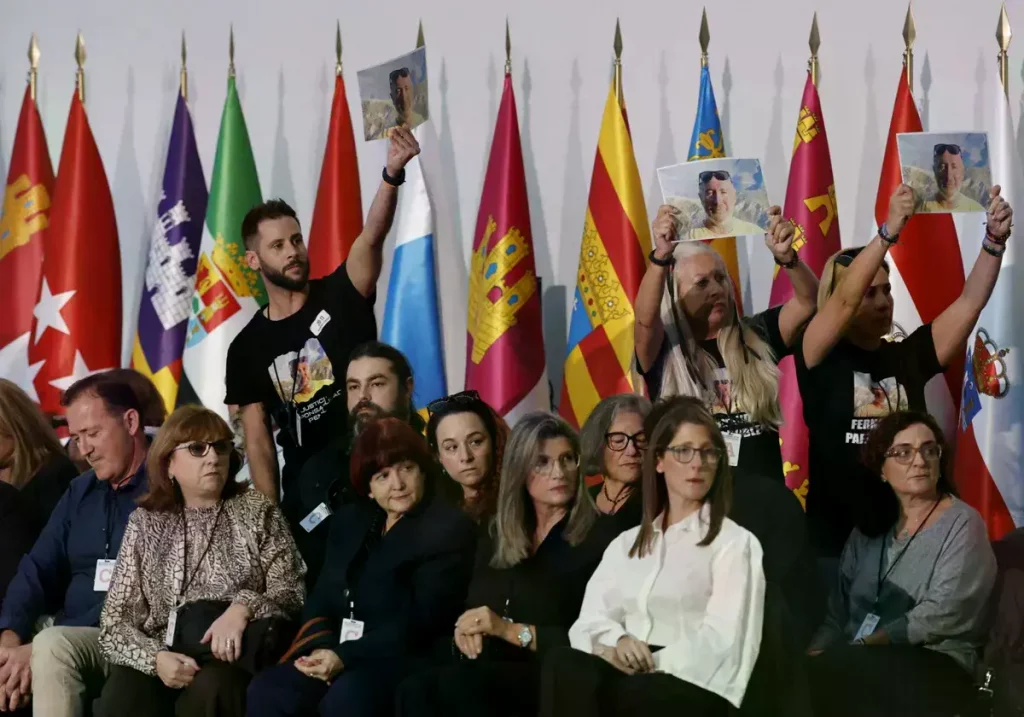 Familiares de las víctimas muestran fotografías durante el homenaje