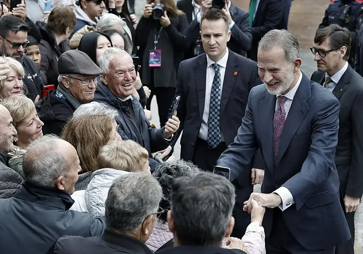 El rey Felipe VI saluda a vecinos a su llegada a L'Hospitalet de Llobregat.