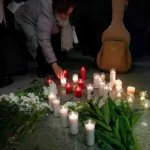 Una mujer deposita una vela en memoria de los fallecidos en el accidente de Adamuz.