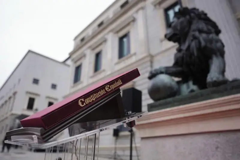 Ejemplar de la Constitución Española ante los leones del Congreso de los Diputados