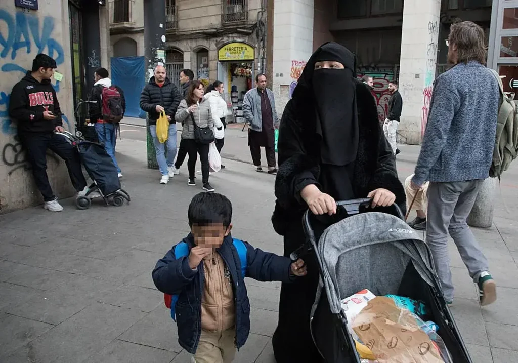 Una mujer con burka camina por el barrio de El Raval de Barcelona.