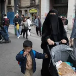Una mujer con burka camina por el barrio de El Raval de Barcelona.