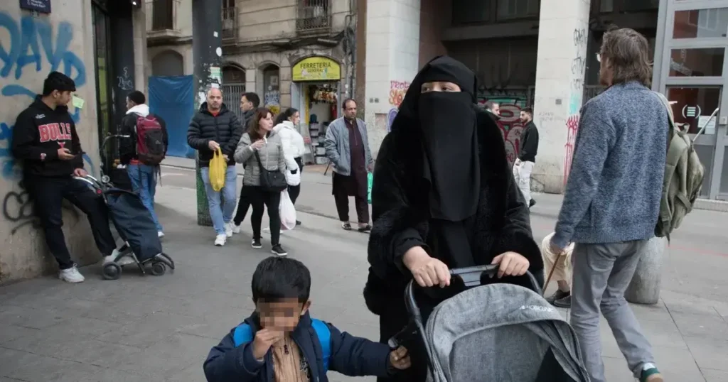 Una mujer con niqab camina por el barrio de El Raval de Barcelona