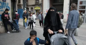 Una mujer con niqab camina por el barrio de El Raval de Barcelona