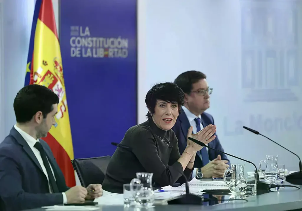 El ministro de Sumar Pablo Bustinduy mira a la ministra portavoz, Elma Saiz, en una comparecencia.