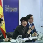 El ministro de Sumar Pablo Bustinduy mira a la ministra portavoz, Elma Saiz, en una comparecencia.