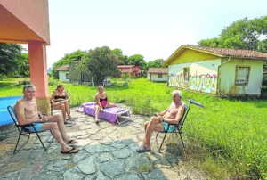 Vecinos toman el sol en medio de construcciones derruidas. (Paloma Ucha)