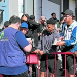 Inmigrantes hacen cola para ser atendidos.