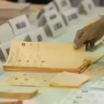 Un residente español toma una tarjeta para votar en el Consulado General de España, en las últimas elecciones generales.